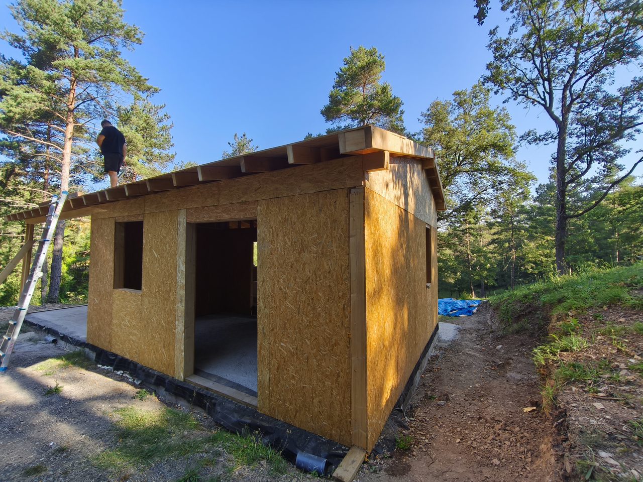 Interior de casa de entramado ligero con viguetas de madera y tablero OSB en cubierta